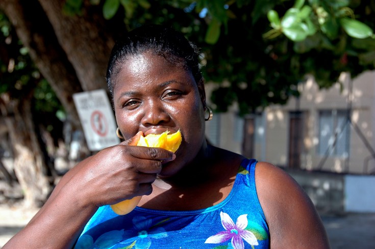 Lera eating a mango on the beach